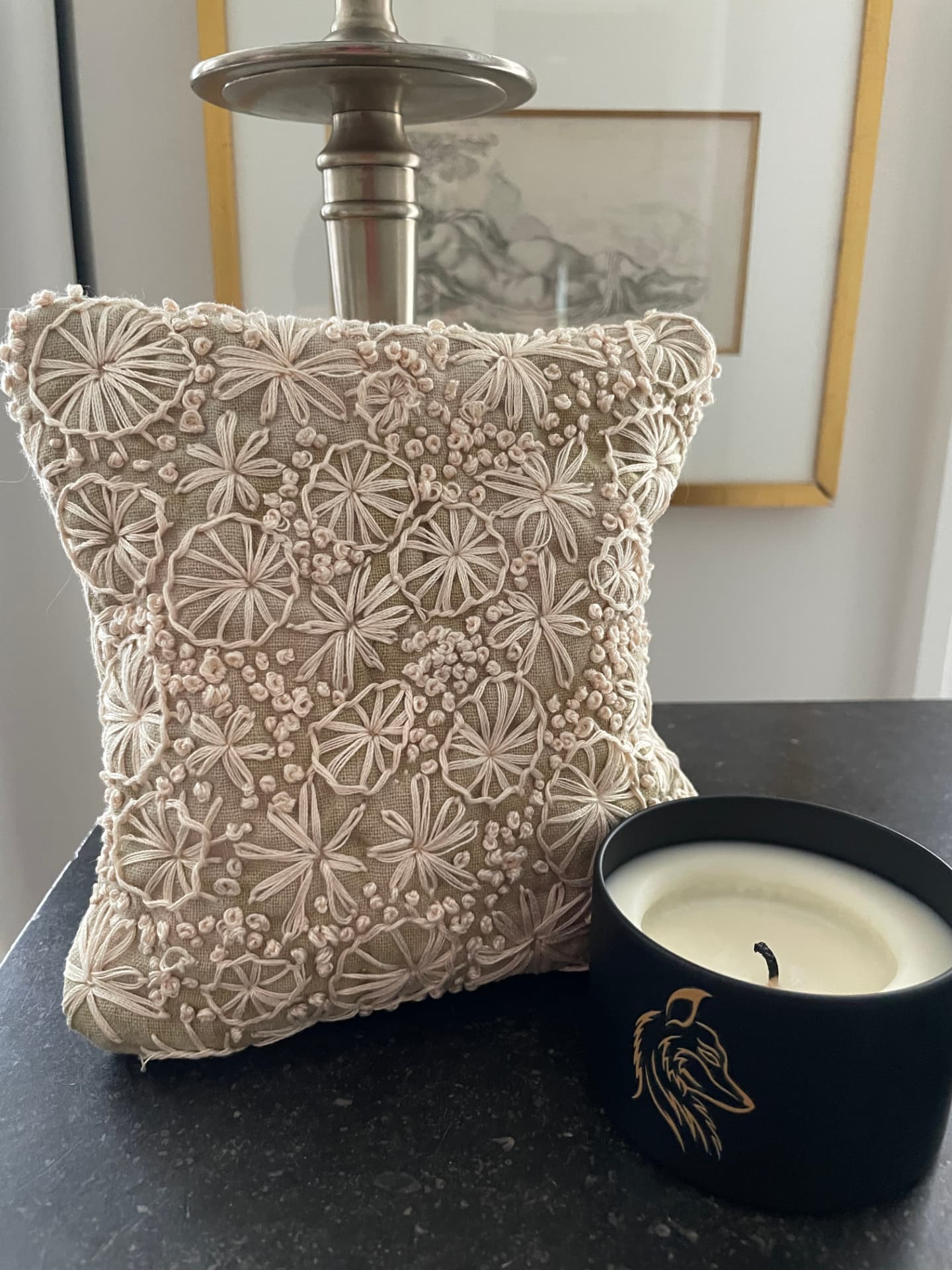 Small linen pillow covered in hand-embroidered pale pink flowers and French knots