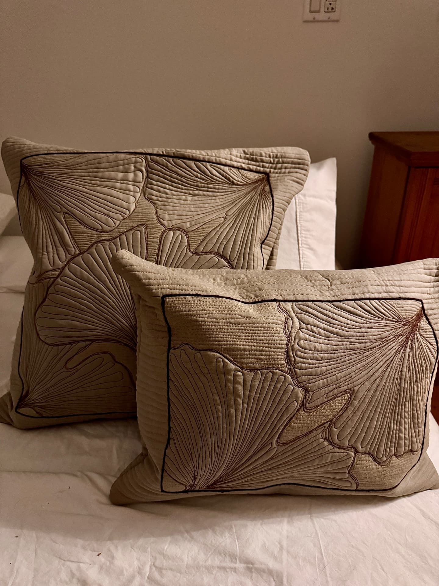 Two quilted linen pillows stitched with large ginkgo leaves